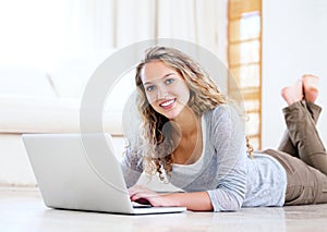 Laptop, portrait and happy woman on floor in home, typing email and network on internet. Computer, smile and face of