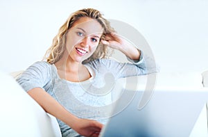 Laptop, portrait and smile of woman on sofa in home, email and networking. Computer, happy person and face of girl in