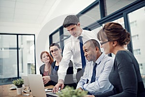 Laptop, presentation and man in a meeting with his colleagues in the office conference room. Technology, teamwork and