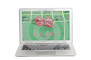 Laptop with red dice on a game table in casino on screen