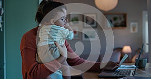 Laptop, remote work or multitask with a mother and baby in their home in the evening for overtime. Computer, family and