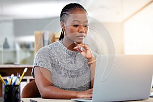 Laptop, research and a business black woman thinking while working at her desk in her office with flare. Computer