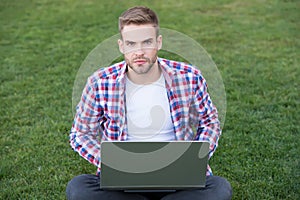 Laptop that is right to blog. Young blogger use laptop on green grass. Handsome man with laptop computer outdoors