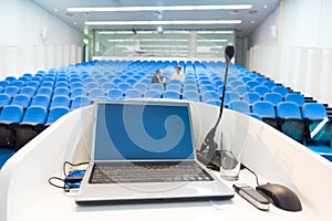 Laptop on the rostrum in conference hall.