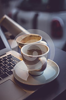 A laptop`s keyboard and a cup of coffee.