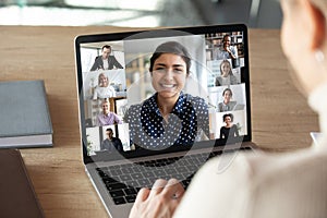 Laptop screen over woman shoulder view during group online communication photo