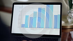 Laptop screen sliding charts closeup. Manager hands typing keyboard analyzing