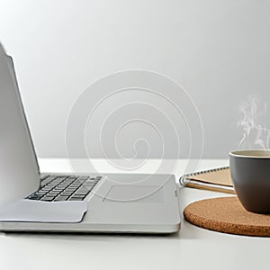 Laptop with a silver body on a white desk, open with a visible keyboard and trackpad. photo
