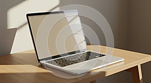 A laptop with a sleek silver body and black keyboard is open on a light wooden table.