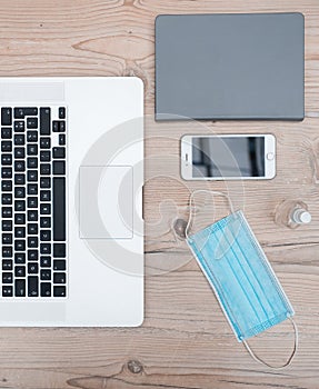 Laptop, smartphone and protective mask on the office Desk