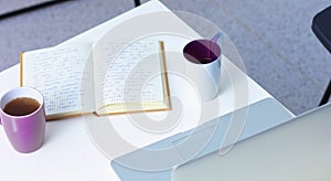 Laptop with stack of folders on table white background