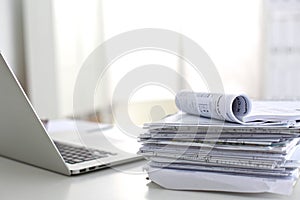 Laptop with stack of folders on table white background