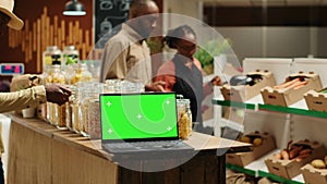 Laptop on stall at supermarket showing greenscreen template