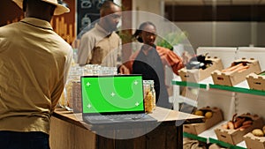 Laptop on stall at supermarket showing greenscreen template