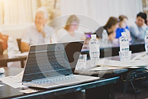 A laptop stands on a table in a room for business meetings and negotiations