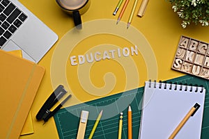 Laptop and stationery on yellow background. Back to school concept.