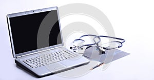 Laptop ,stethoscope and x-ray on the table