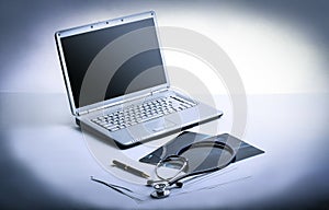 Laptop ,stethoscope and x-ray on the table