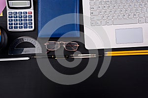 Laptop with studying tools on dark table