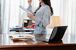 Laptop on the table and student hold documant background. Student learning at home photo