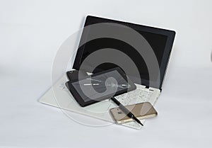 a laptop, a tablet with a cracked screen, smartphones on a light background.