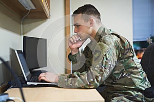 Laptop, thinking and military man with security software, online research and law academy in office. Planning, soldier