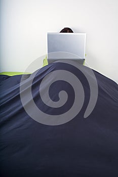 Laptop on top bedcover mountain