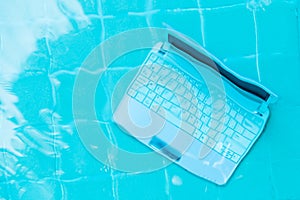 Laptop under water. Minicomputer at the bottom of the pool. The concept of obstruction at work. Blur abstract background