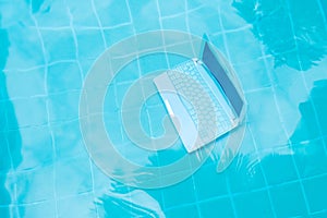 Laptop under water. Minicomputer at the bottom of the pool. The concept of obstruction at work. Blur abstract background