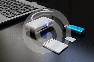 Laptop with USB Type-C adapter with pluged USB cables and SD card. The USB adapter under the Type-C connector for laptop