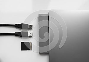 Laptop with USB Type-C adapter with pluged USB cables and SD card. The USB adapter under the Type-C connector for laptop