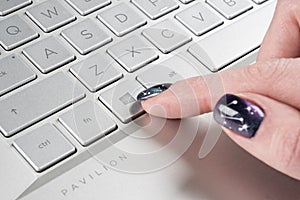 Laptop user finger pressing Windows icon key button on Microsoft Windows keyboard. Woman hand pressing Microsoft Windows key with