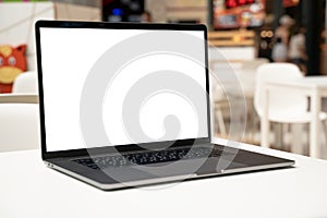 Laptop with white screen in business office or shopping mall. Empty copy space, blank screen mockup. Soft focus laptop
