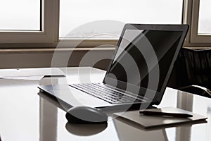 Laptop with white screen mock up template. Office desk with computer; coffee cup and pen