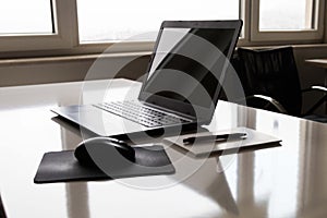 Laptop with white screen mock up template. Office desk with computer; coffee cup and pen