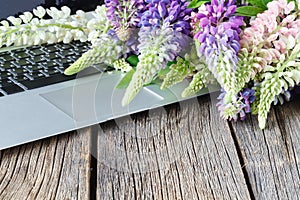 Laptop on wooden floor with flowers