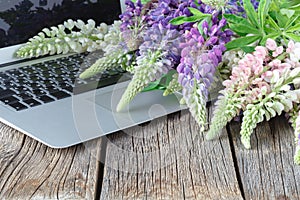 Laptop on wooden floor with flowers