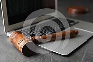 Laptop and wooden gavel on grey table. Cyber crime