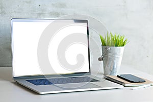 Laptop on work desk showing white blank screen