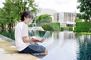 Laptop Work by the Poolside for Businessman on Vacation in Casual Wear