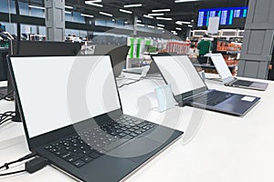 Laptops with a white screen at the showcase in the electronics store. Buy a laptop in a technology store