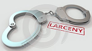 LARCENY stamp and handcuffs. Crime and punishment related conceptual 3D rendering