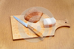 Lard, knife and rye bread on cutting board