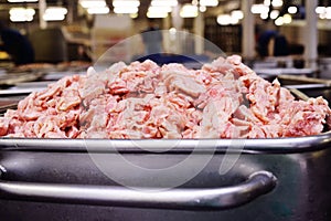 Lard, pork or ground beef in metal containers in food production at a meat processing plant.