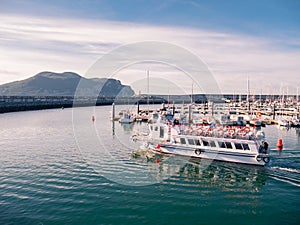 Pleasure boat sailing through the modern marina of Laredo at sunset