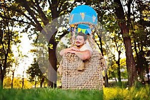 a large adult bearded man in the basket of a toy balloon.