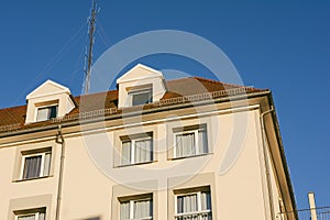 Large aerial antenna communication dish on the rooftop of apartment building