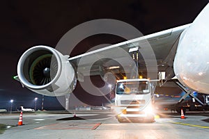 Large aircraft jet engines, Fueling a huge airplane, a truck with fuel with hoses connected to a fuel tank.