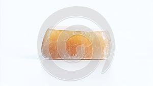 A large block of amber-colored salt crystal on a white background for natural product marketing photo