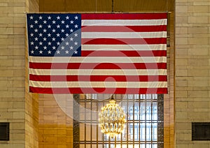 Large American flag and chandelier inside Grand Central Terminal in New York City, New York.